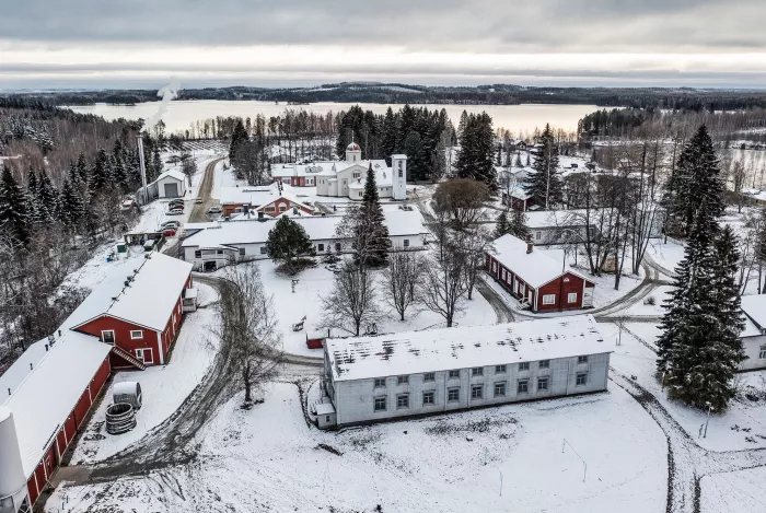 Luostarin rakennukset sijaitsevat tiiviinä ryhmänä Saimaan vesistöön kuuluvan Juojärven rannalla. Etualalla Valkoinen vierasmaja. © Harri Mäenpää