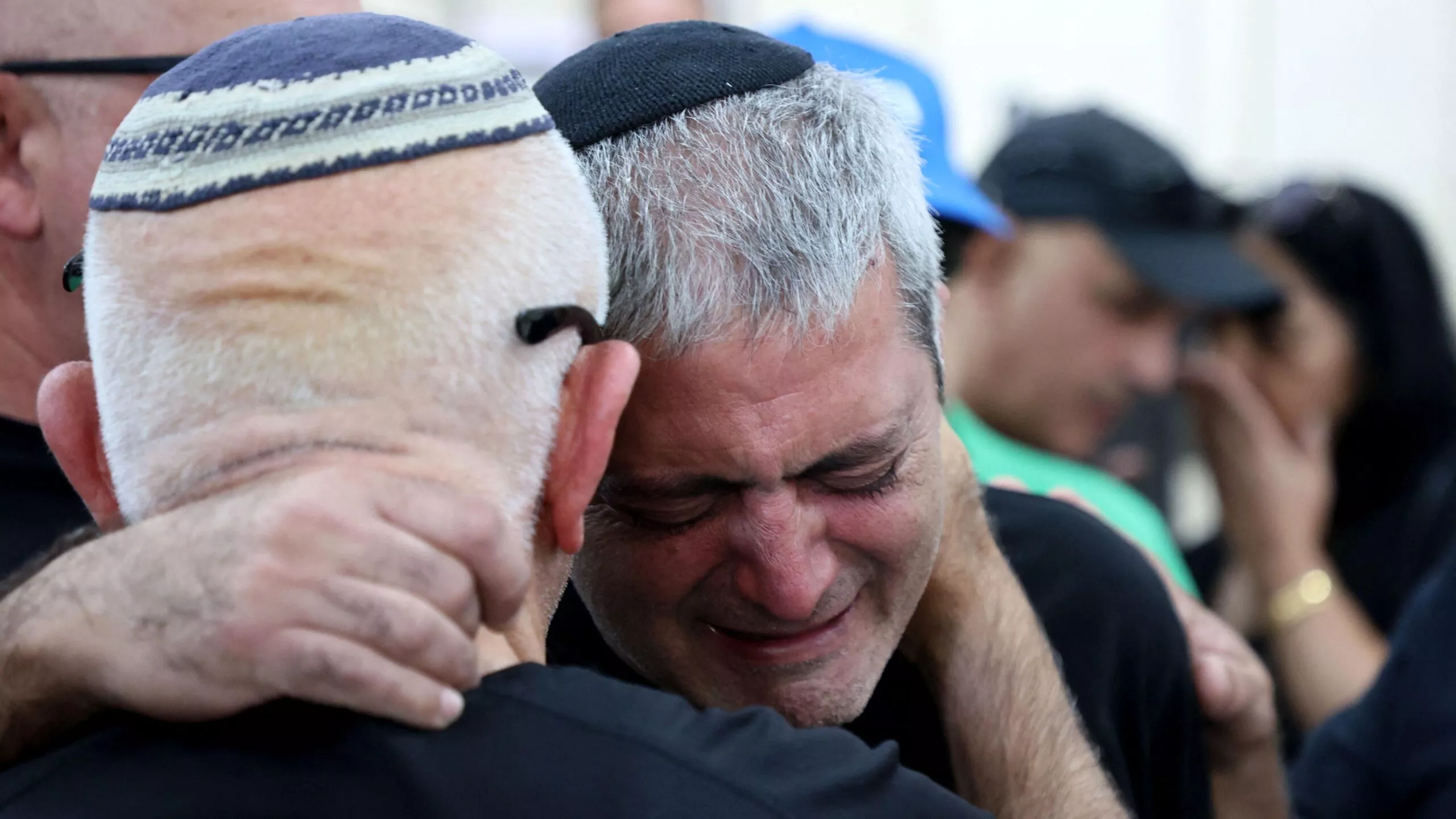 Isää lohdutetaan, kun poika kuoli Hamas-iskussa Kibbutz Kfar Azassa lokakuun 16. päivänä.