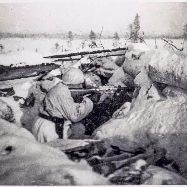 Tähystämässä vihollista Kiskis-kukkulalla kädessä Suomi-konepistooli ja vyöllä isältä saatu Barabellum. Venäläiset ovat noin 70 metrin päässä.