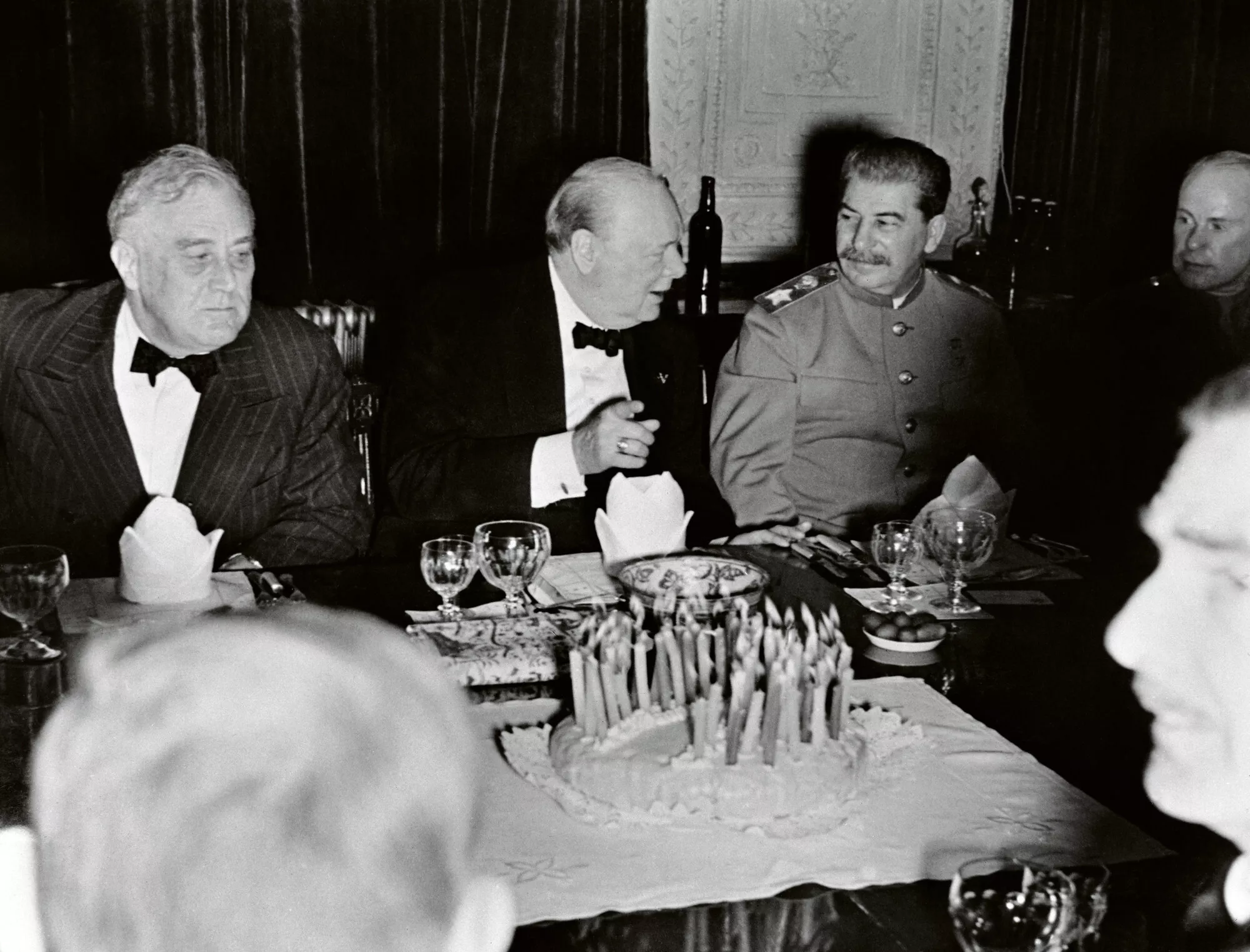 Winston Churchill avaa syntymäpäivänään Teheranissa samppanjapullon. Vasemmalla Franklin D. Roosevelt, oikealla Josif Stalin.