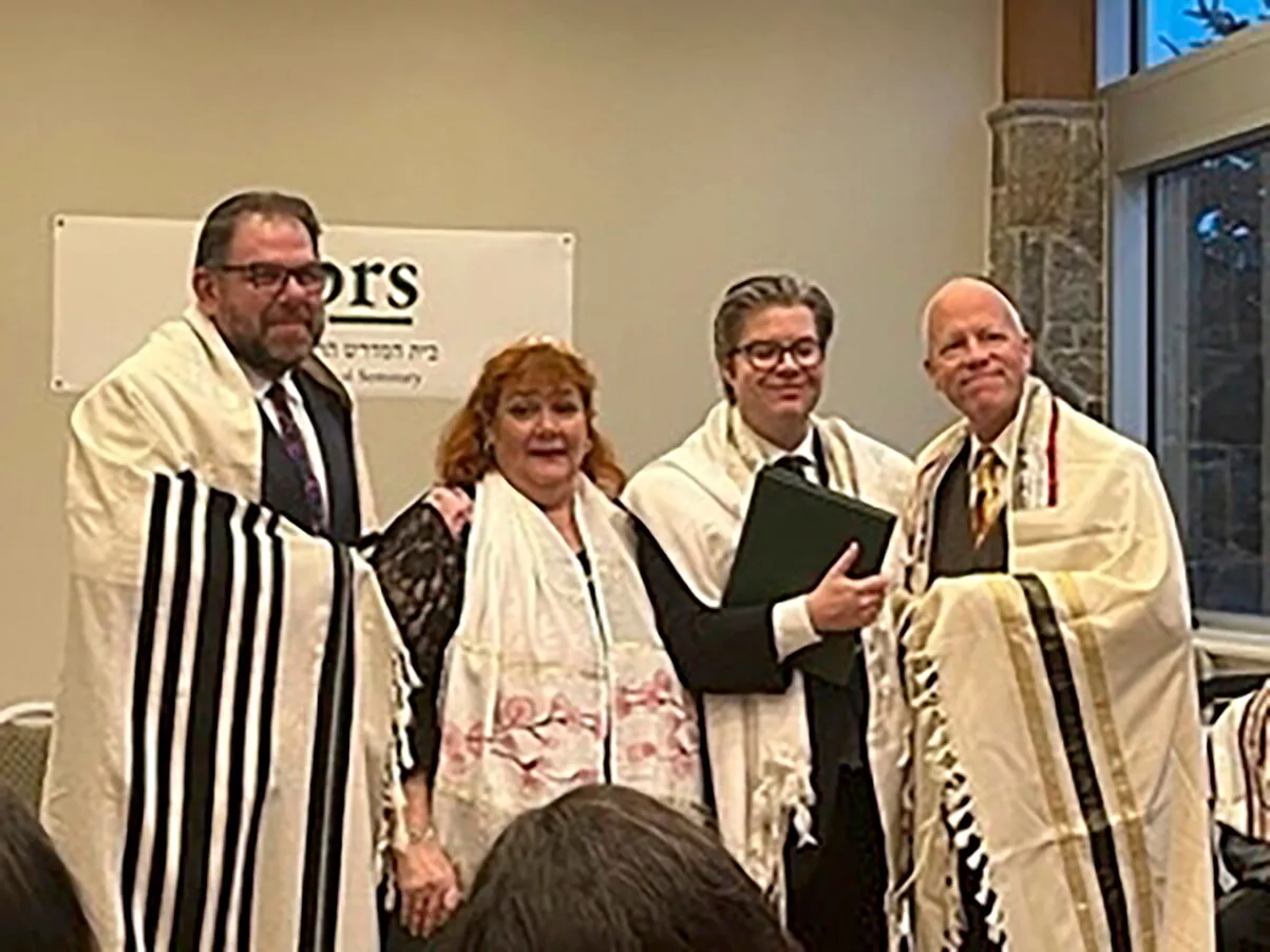 Neljä ihmistä seisoo rinnakkain kuvassa, keskellä Laila Takolander, joka on juuri valmistunut rabbiksi.