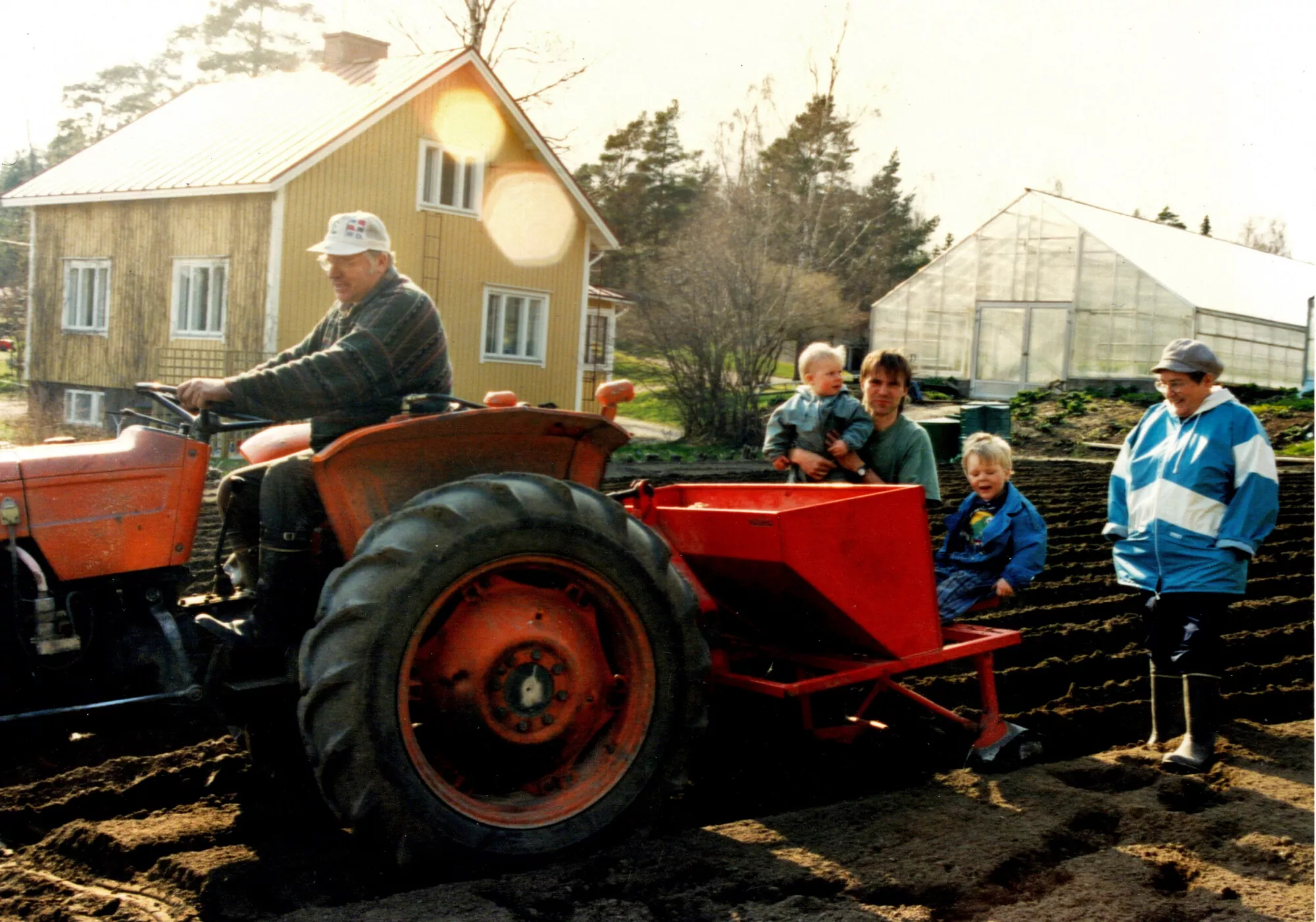 Perhe perunan istutuksessa: Kaijuksen isä Putte ajaa traktoria, kyydissä istuvat Kaijus ja pojat. Takana seisoo Kaijuksen äiti Mirkku.