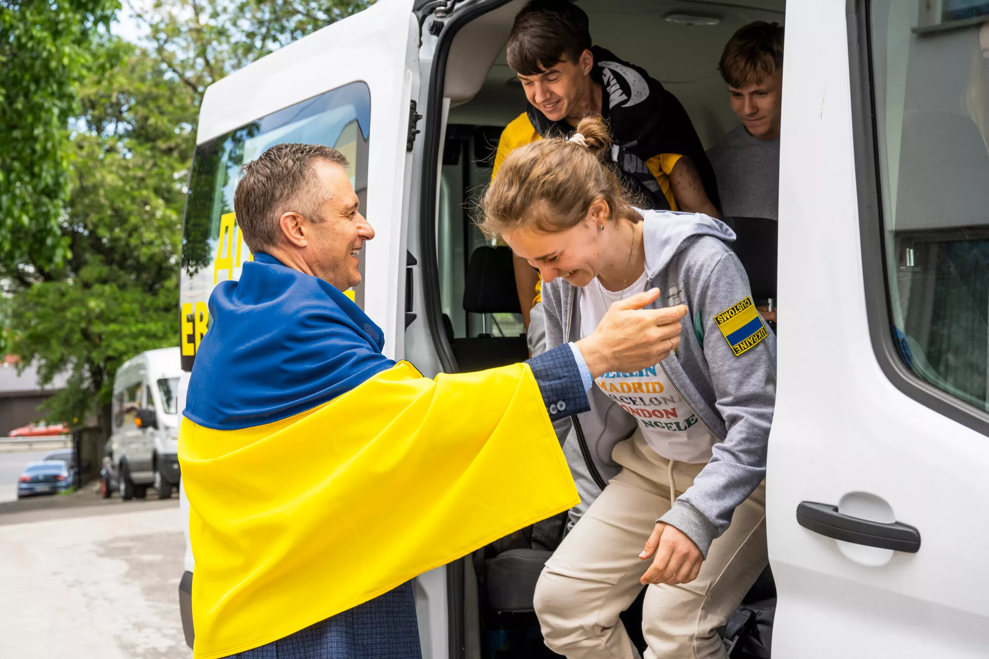 Save Ukrainen toimitusjohtaja Mykola Kuleba halasi kotimaahan palaavaa Lidiiaa pitkään ja kietoi ­hänet sitten Ukrainan ­lippuun.