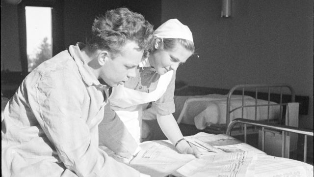 Suomen sotien aikana lääkintälotat viettivät aikaa potilaiden kanssa esimerkiksi lehteä lukien.