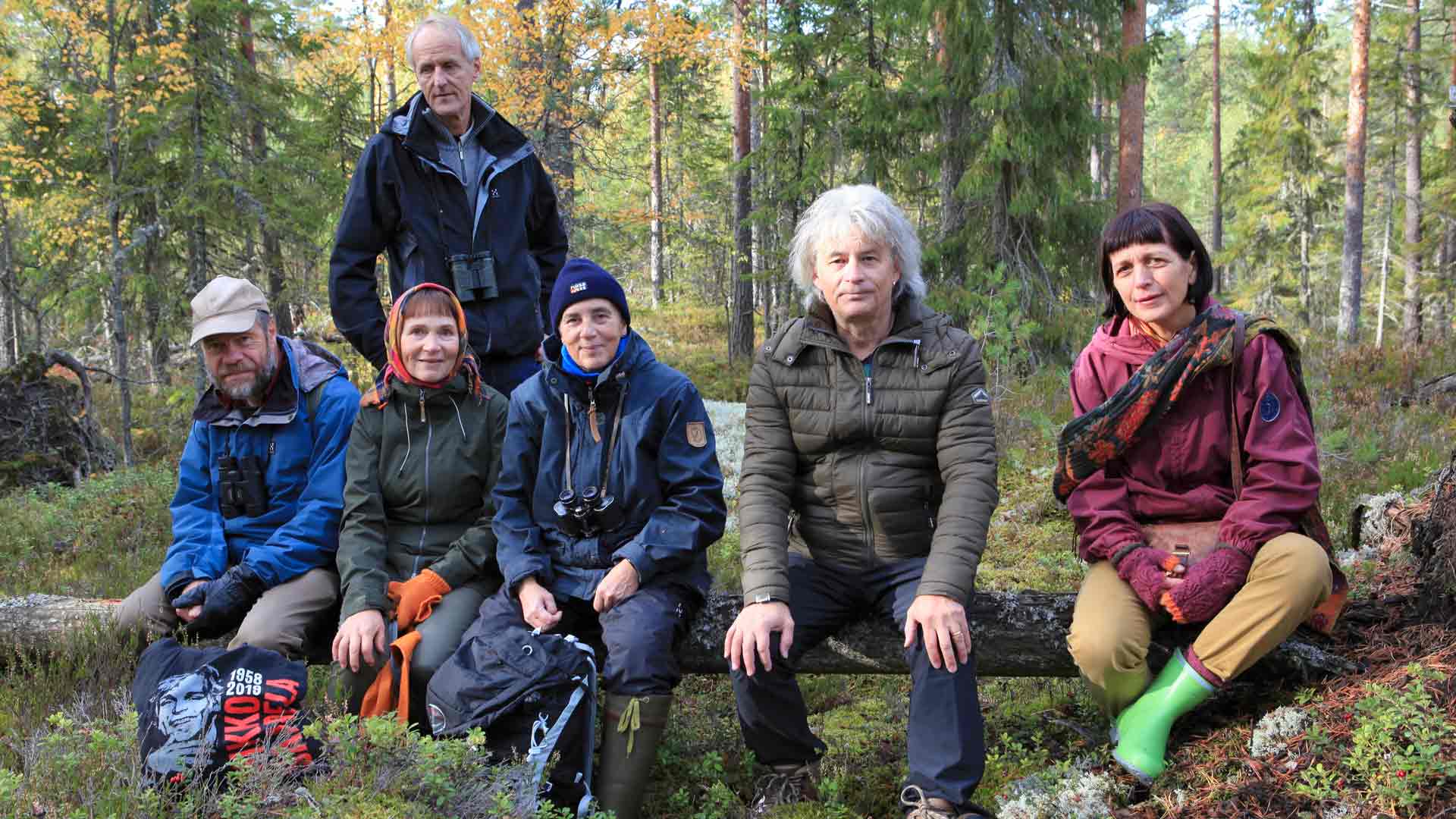 Matti Salminen katsoo takaa, kun Jukka Ruuhijärvi, Maritta Liedenpohja, Anneli Leivo, Juha Torvinen ja Eeva Saarela istuvat levähdyspaikalla.