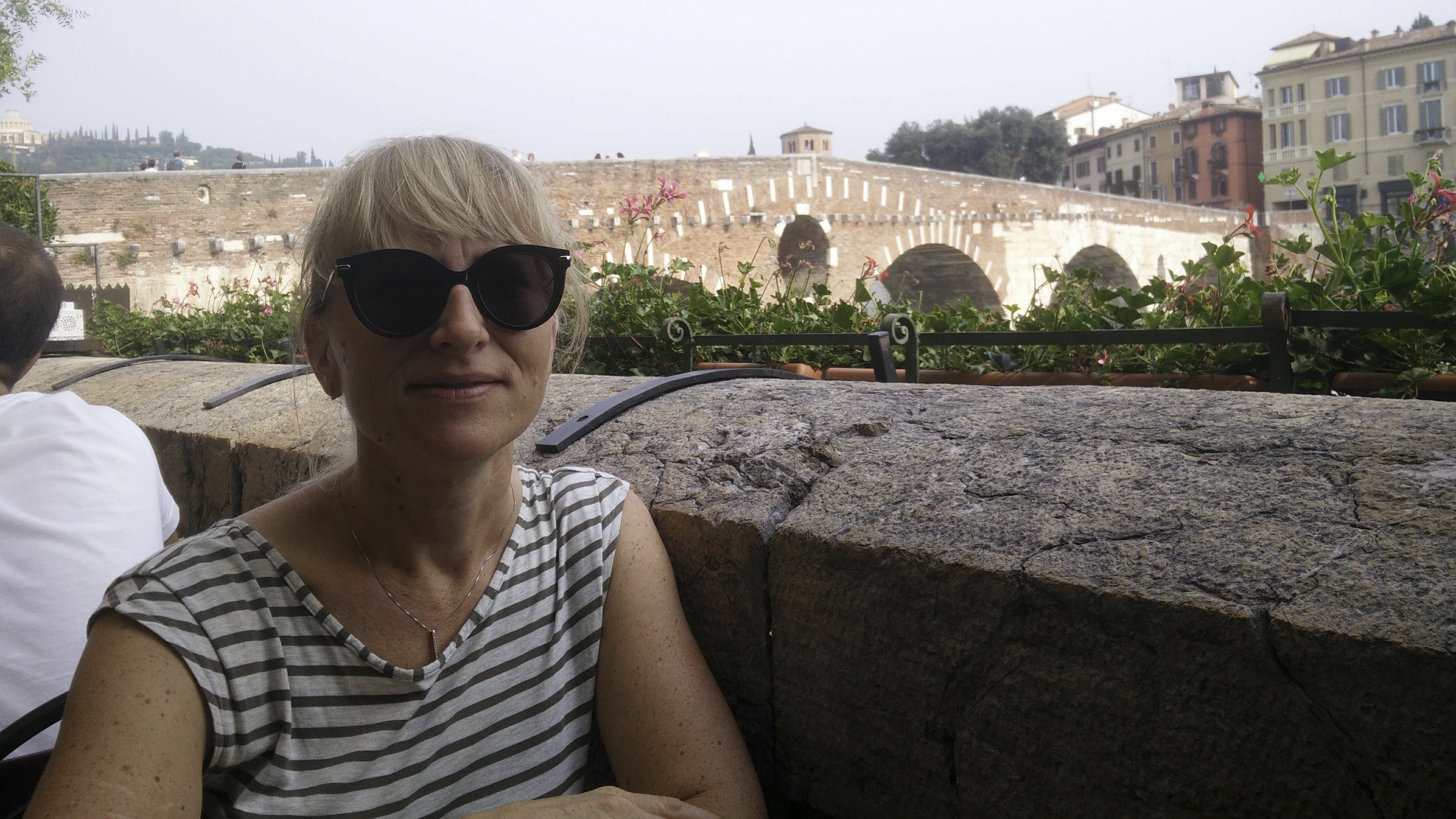 Sanna Kallio kotikaupungissaan Veronassa. Taustalla näkyy Ponte Pietran silta, matkailunähtävyys. Nyt koronapandemia on tyhjentänyt Veronan kadut.