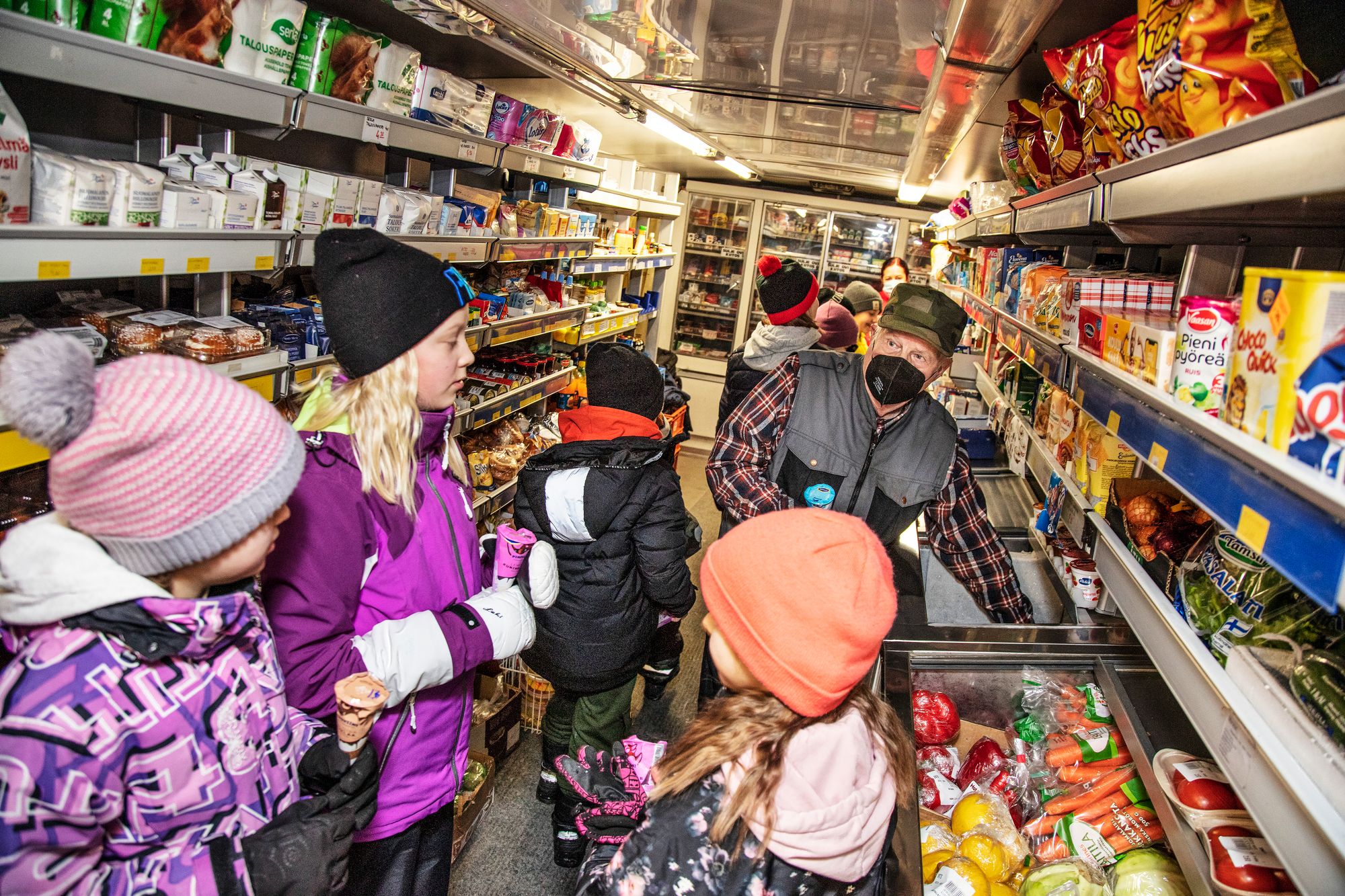 Siikasalmen kristillisen koulun oppilaat tutustuvat kauppa-auton sisältöön. Matti tarjoaa oppilaille jäätelöt. © Harri Mäenpää
