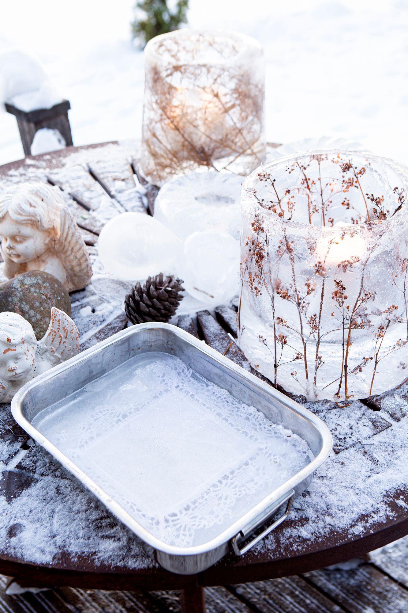 Pirjo on tehnyt kauniin jäälyhdyn kuivuneista luonnonkukista. Pakkanen jäädytti ämpärin kukat ja veden yön aikana. © Tiiu Kaitalo