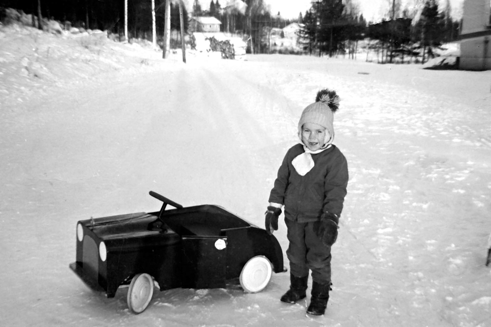 Oravikosken kaivoskylä 1964. Mikko isänsä rakentaman polkuauton koeajolla. © Omaelämäkerta
