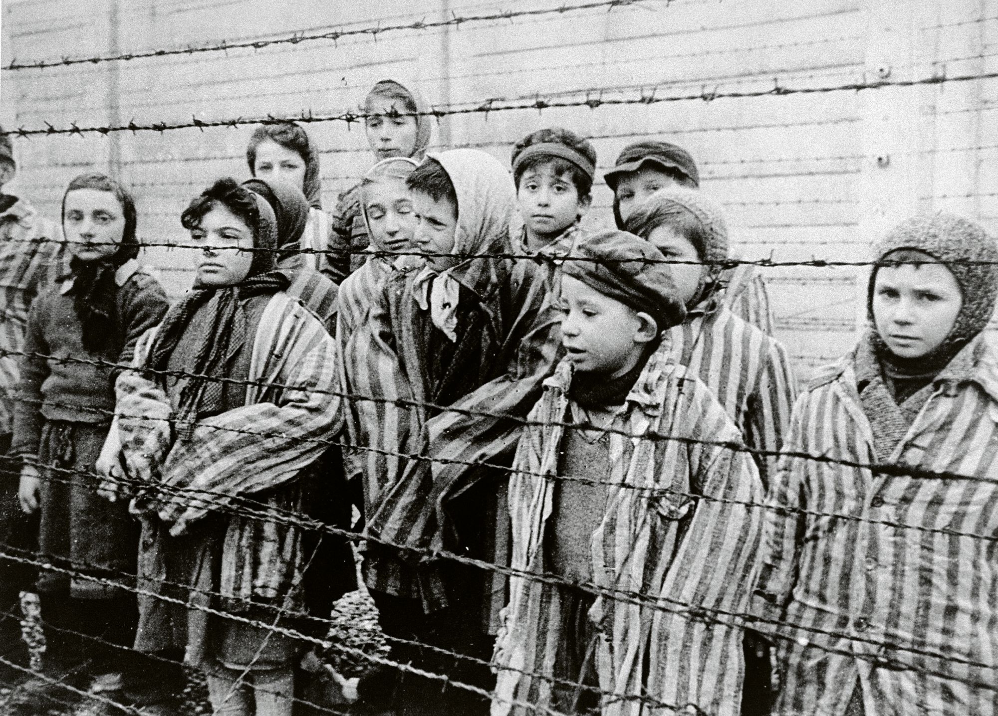 Kohti Berliiniä etenevät Neuvostoliiton joukot vapauttivat Auschwitzin vangit tammikuussa 1945. Kuvassa näkyy aidan takana naisten lisäksi lapsia aikuisten vankien asuissa. © Universal Images Group / Lehtikuva