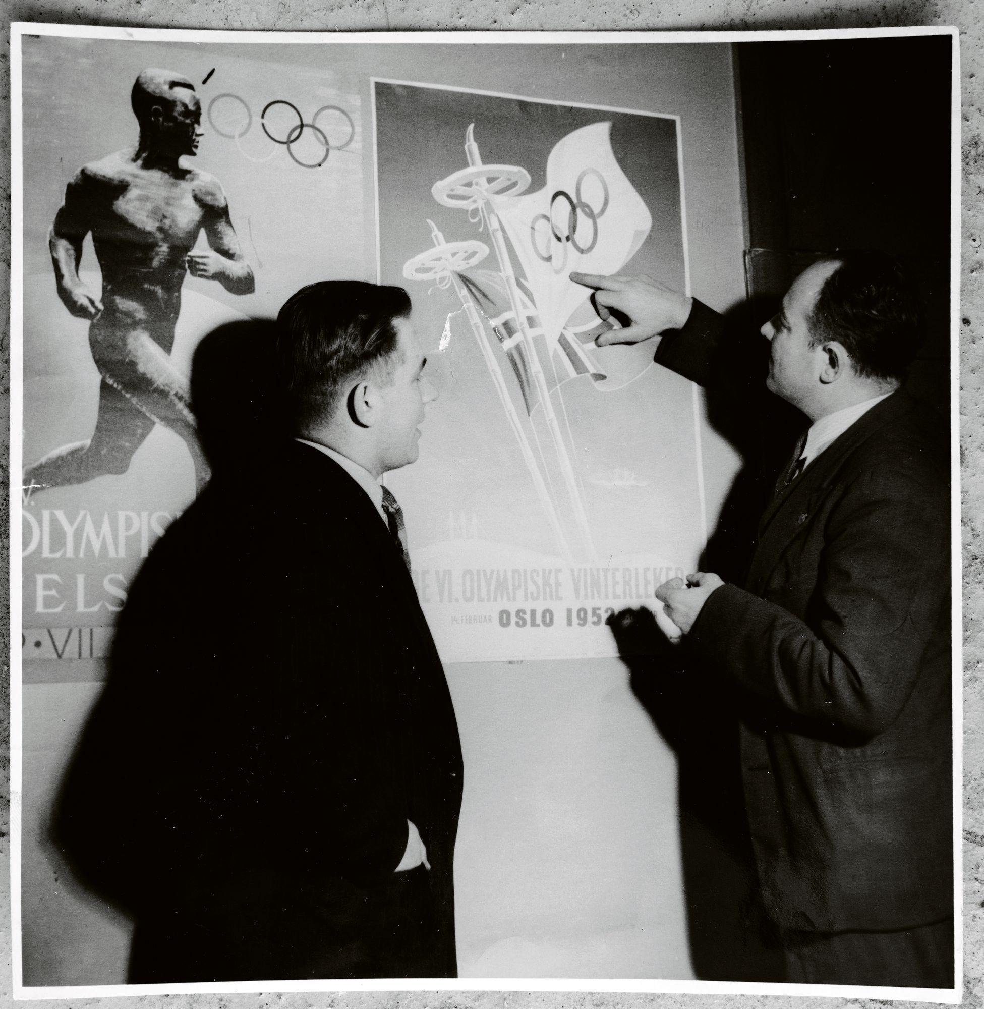 Pentti Salmi (vas.) tutki vuonna 1952 Helsingin olympialaisten ja Oslon saman vuoden talviolympialaisten julisteita työ­toverinsa kanssa. © Salmen kotialbumi