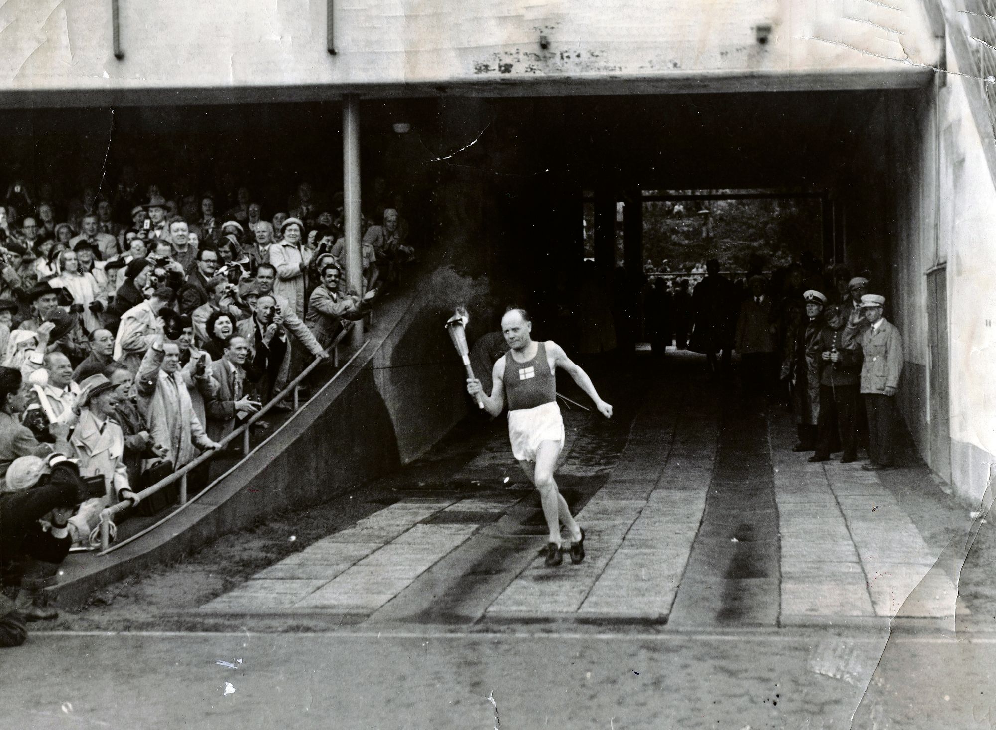 Paavo Nurmi tuo olympiasoihdun maratonportin kautta kisojen avajaisiin. © YHTYNEET KUVALEHDET OY/KUVA-ARKISTO