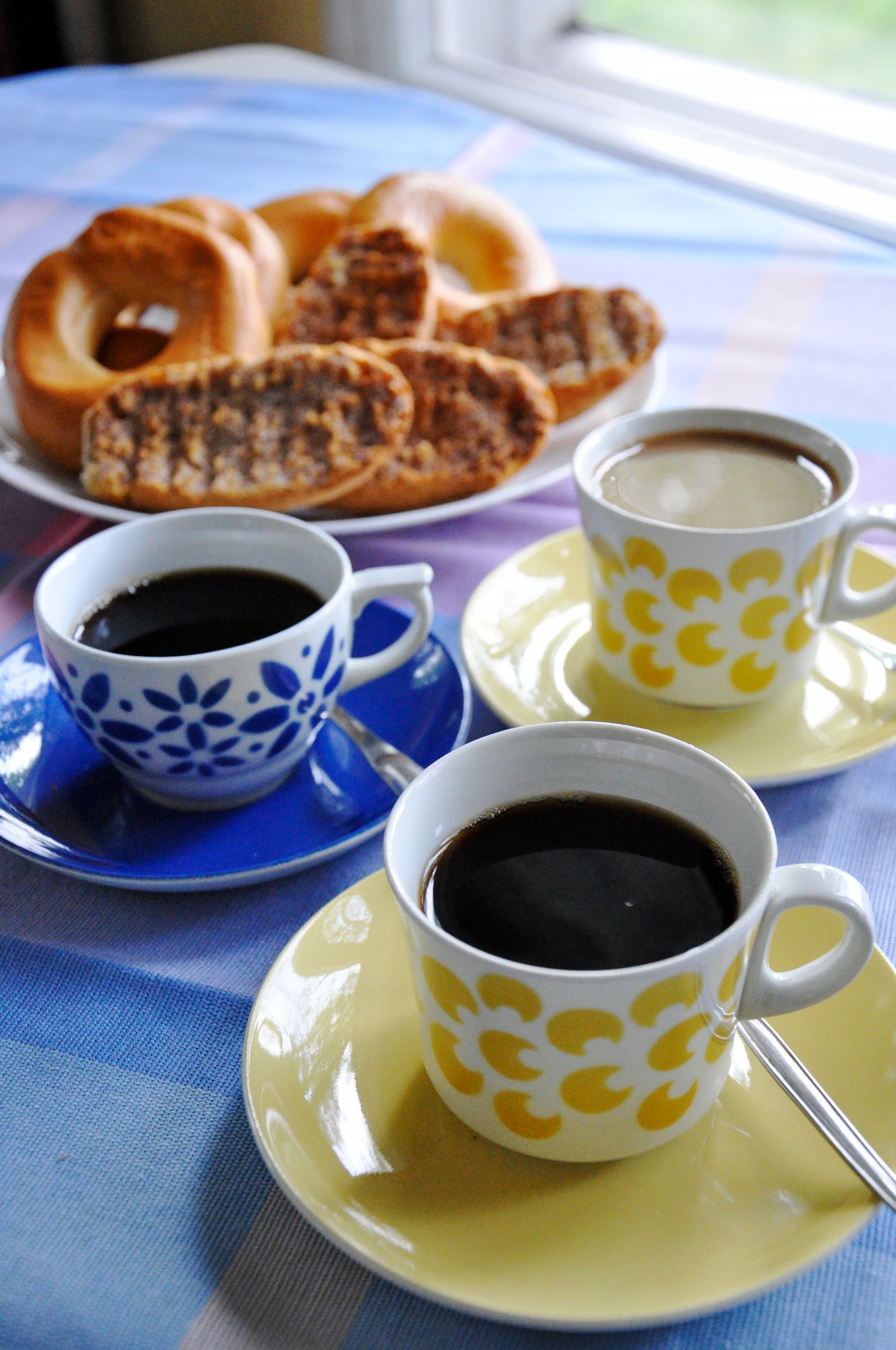 Kahvi on katettu mummolan pöytään. Vasemmalla juojia odottelee sininen Armi-kuppi. © Anna Muurinen