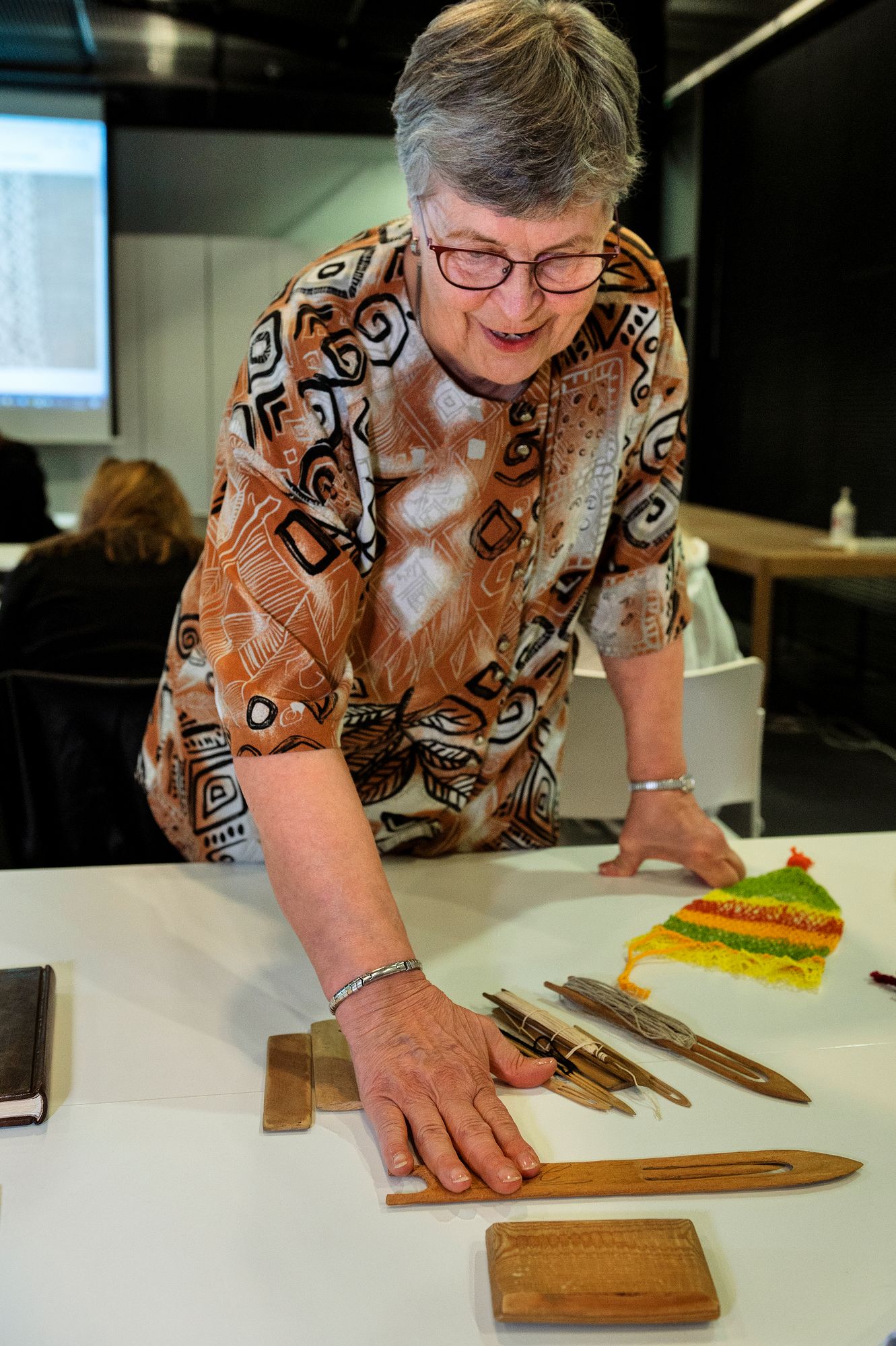 Pirjo Sunila esittelee perinteisiä verkkopitsin kutomisen välineitä. © Linda Varoma