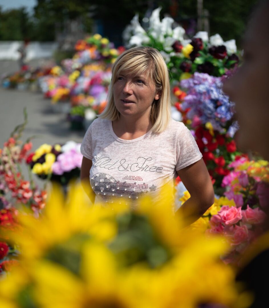 Nainen myy kukkia ukrainalaisella hautausmaalla.