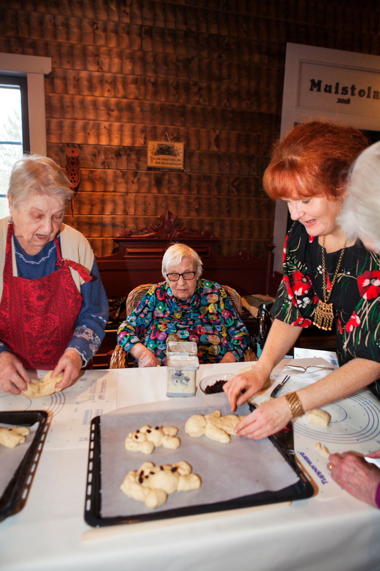 Eva (vas.) kertoo olevansa itseoppinut leipuri. Tuija (kesk.) seuraa pullapoikien tekoa. © Mandi Säilä