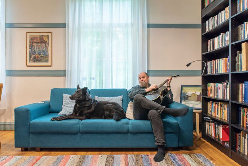 Sakari Neuvonen on soittanut pitkään bändissä. Musisointia kuuntelee Enigma-koira. © Pauliina Salonen