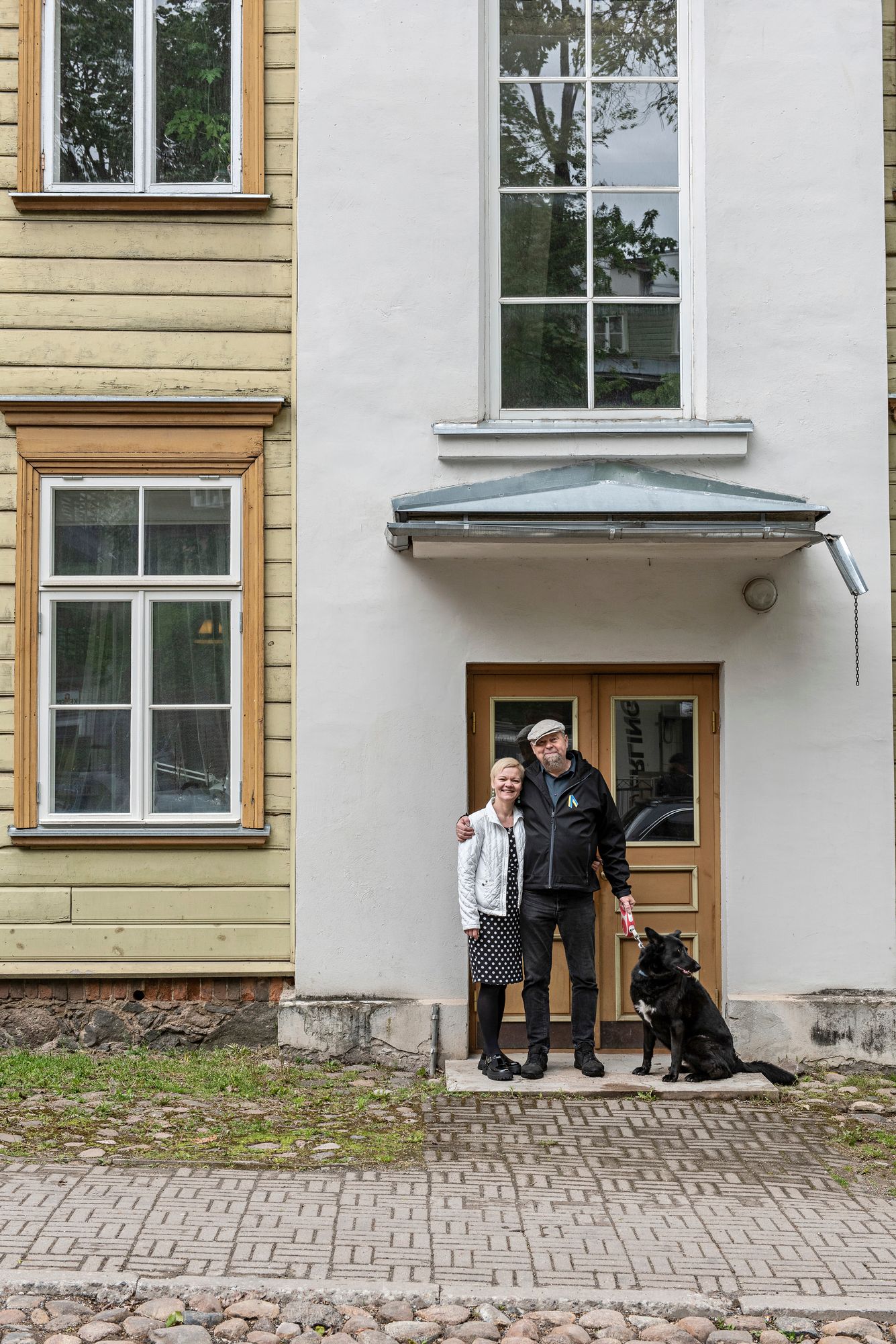 Tiia ja Sakari Neuvonen sekä perheen Enigma-koira viihtyvät 1800-luvun lopulla rakennetussa hirsitalossa. Sillä on keskeinen sijainti Tarton keskustassa. © Pauliina Salonen