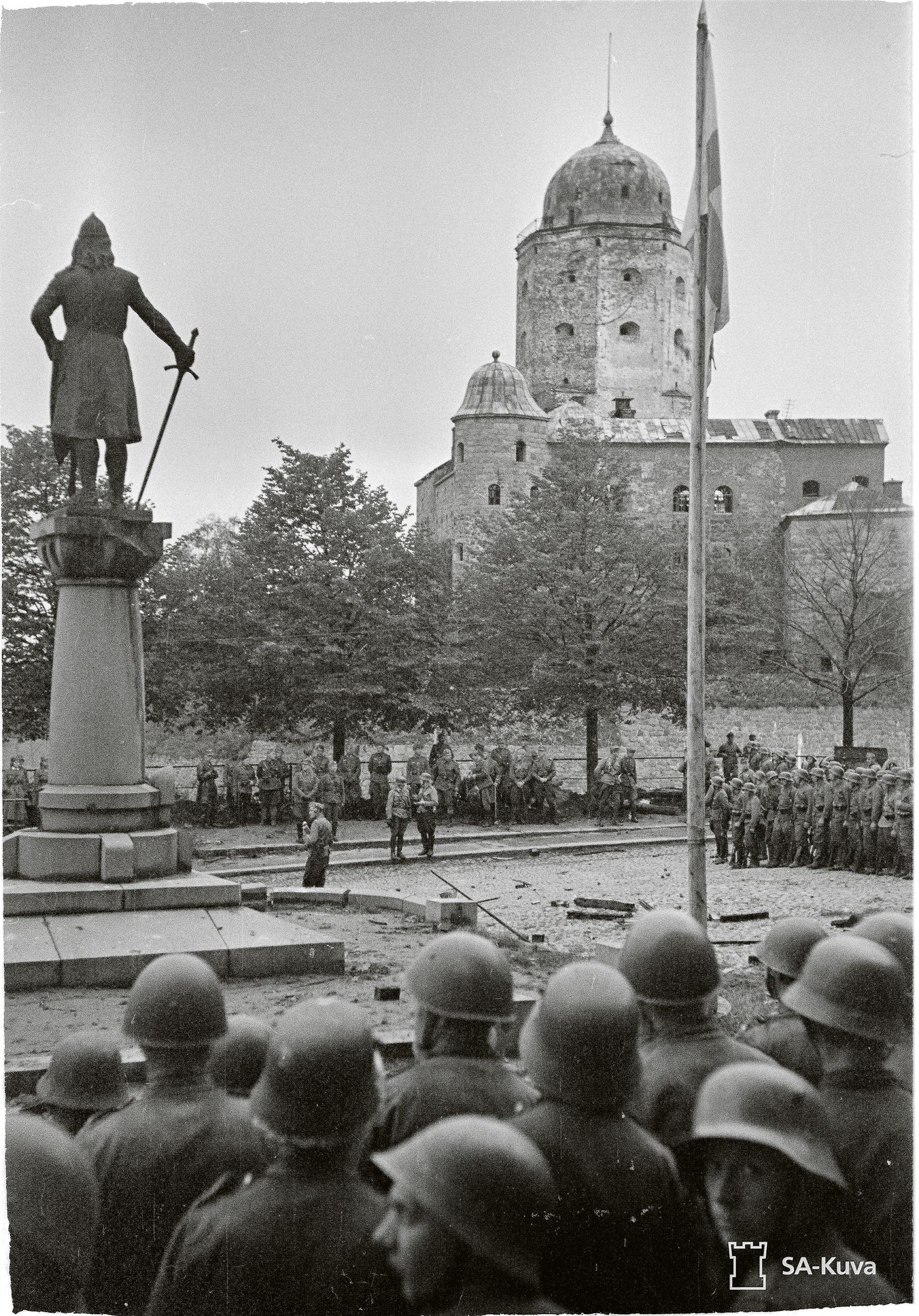 Viipuri oli jälleen Suomen elokuussa 1941. Ryhmä kaupungin takaisin vallanneita sotilaita edessään Viipurin linna ja sen perustajan Torkkeli Knuutinpojan patsas. © SA-kuva
